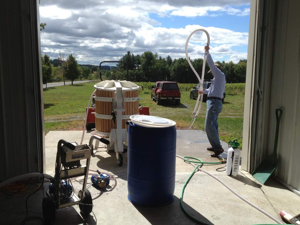 Cleaning up after pressing grapes Gerry is cleaning hoses in the winery after pressing.