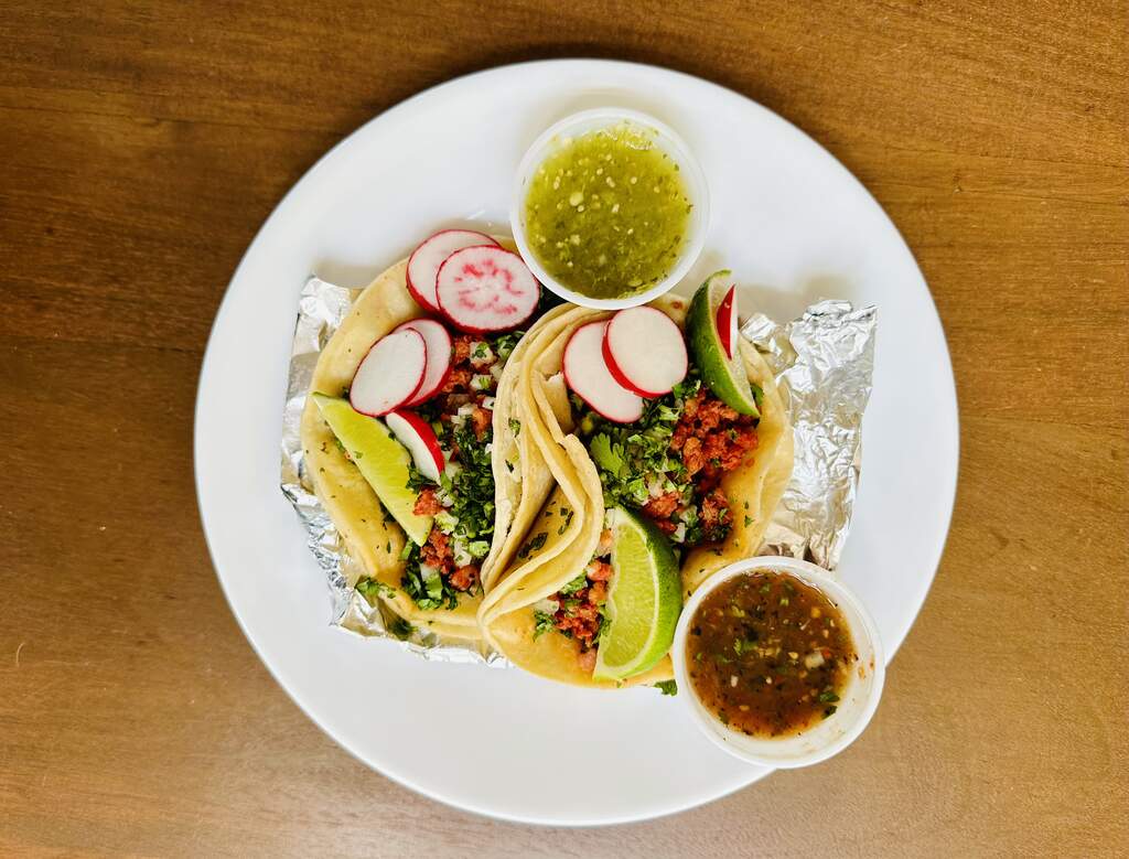Tacos Plate of tacos with salsa, lime wedges and sliced radishes.